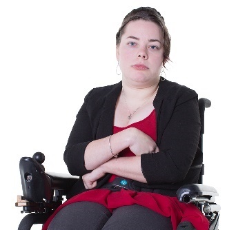 A woman in a wheelchair looking upset, with her arms crossed.